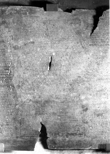 Fragmento en fotografía de la Lex Ursonensis (CIL II²/5, 1022), capítulo CXXVII, inscrita en bronce, con texto legal latino parcialmente conservado.